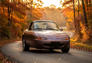 Mazda MX-5 NA classique sur une route de campagne au coucher du soleil, illustration pour guide collection automobile débutant