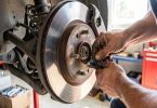 Gros plan sur un disque et étrier de frein avec contrôle de l'épaisseur des plaquettes dans un garage