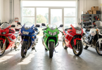Cinq motos de collection des années 80-90 alignées dans un garage ensoleillé : Honda VFR, Yamaha Ténéré, Kawasaki ZXR, Ducati 916 et BMW GS