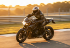 Motard en combinaison de course penche dans un virage sur circuit